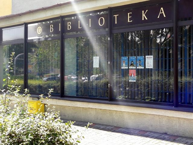 Witryna biblioteczna z białym napisem na brązowym tle: "13 Biblioteka"