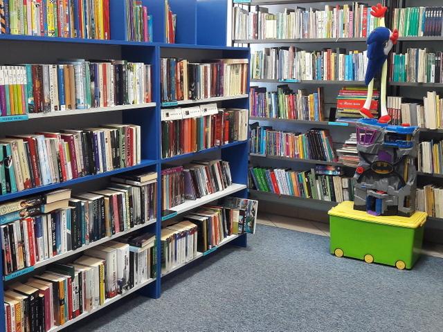 Fragment kącika z księgozbiorem dla dzieci i zabawkami.