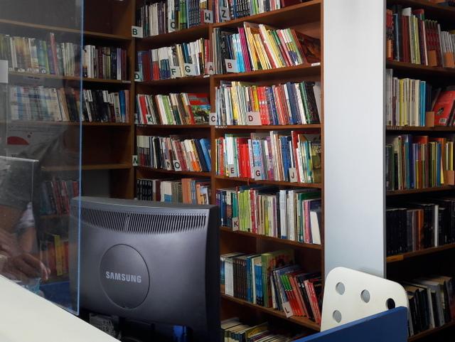 Stanowisko do obsługi czytelnika. W tle regały z książkami.