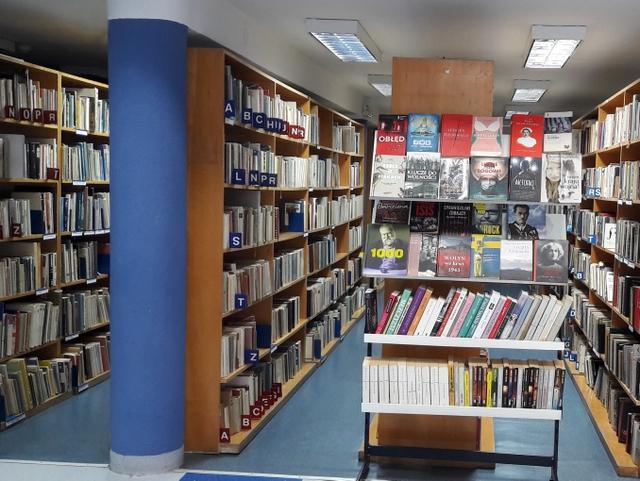 Widok na regały z książkami i wystawkę nowości.