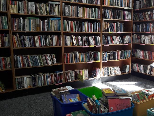 Fragment czytelni działu. Wzdłuż ścian widoczne regały z książkami.