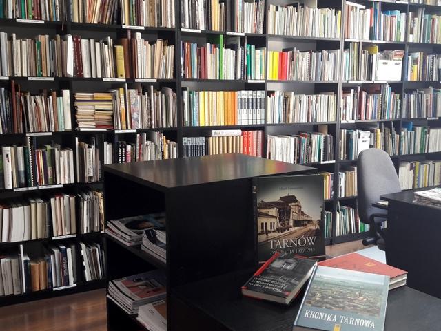 Stanowisko obsługi czytelnika, w tle regały z książkami.
