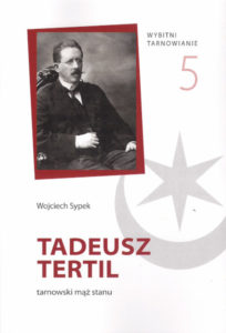 Czarno-białe zdjęcie siedzącego mężczyzny z długimi wąsami i okrągłymi okularami.
