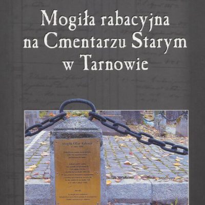 Na okładce fragment ogrodzenia łańcuchowego grobowca ze słupkiem i tablicą Na niej napis Mogiła Ofiar Rabacji, pod spodem nieczytelny tekst.